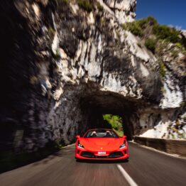 Red Ferrari supercar driving through a tunnel in the Maritime Alps