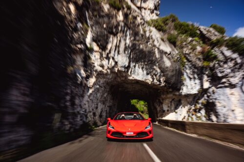 Red Ferrari supercar driving through a tunnel in the Maritime Alps